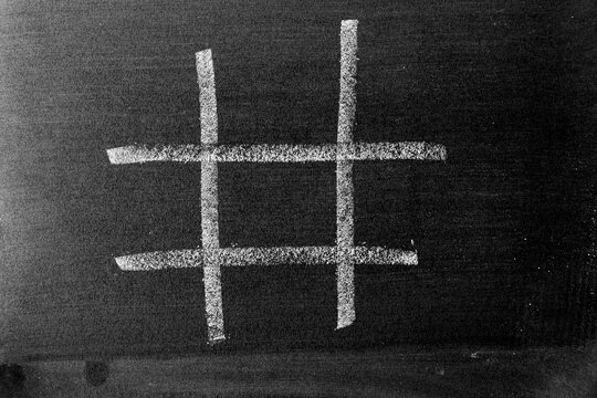 White chalk drawing as hashtag or Tic Tac Toe blank shape on black board background