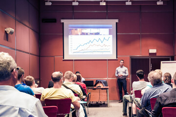 Business speaker giving talk at business conference event.