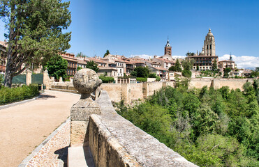 Fototapeta premium Paseo peatonal bordeando las murallas medievales de Segovia con vista de la torre campanario de la catedral, España
