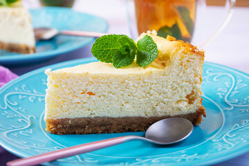 Sliced cheesecake. Delicious sweet cheesecake with mint tea on wooden background