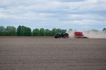 tractor in a field side view, tractor planting crops on an agricultural field. big green tractor...