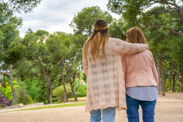Happy family walking in nature park .Mother and her daughter having fun and relaxing outdoors.