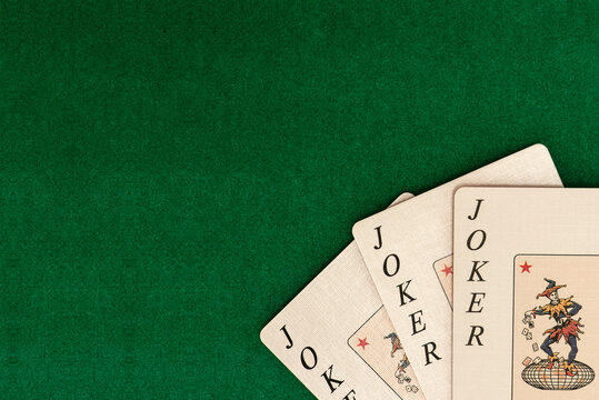 Playing cards on green backdrop of table in casino. Picture with free place for user text or picture.