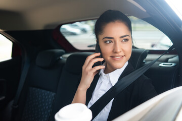 Businesswoman talking on phone in car.