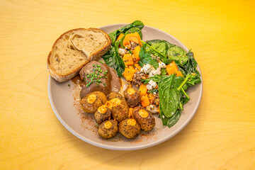 Spectacular cheek with roasted potatoes, a slice of bread and a detox salad on a gray plate