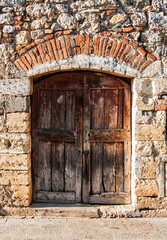 Fototapeta na wymiar Old italian wooden door in Monteriggioni, Italy