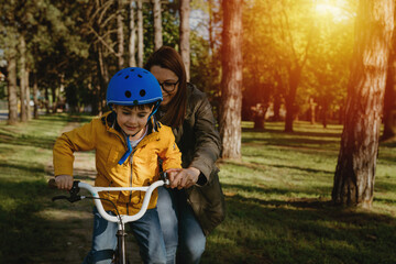 mother and son riding bike in public park