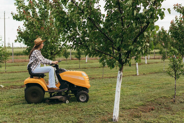 woman rancher driving lawn mower