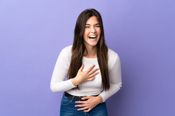 Obraz premium Teenager Brazilian girl over isolated purple background smiling a lot