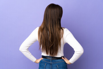 Teenager Brazilian girl over isolated purple background in back position