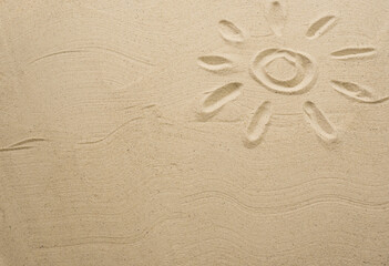 Fototapeta na wymiar Sand texture with painted sun. Empty space for creative design or text. Relax on the sandy beach. Holidays and travel concept