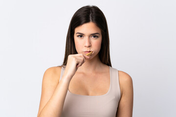 Teenager Brazilian girl brushing her teeth over isolated white background