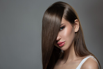 Fashion woman straight shiny hair. Dark gray background