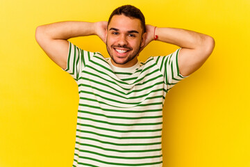 Fototapeta premium Young caucasian man isolated on yellow background feeling confident, with hands behind the head.