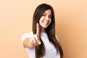 Teenager Brazilian girl over isolated background showing and lifting a finger