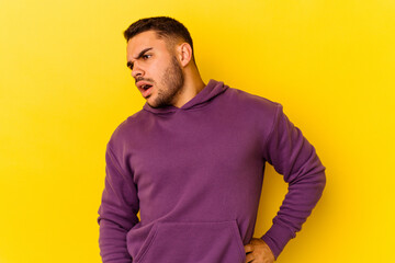 Fototapeta premium Young caucasian man isolated on yellow background suffering a back pain.