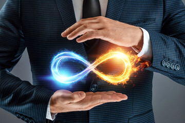 Businessman showing infinity sign, Fire ice sign on gray background