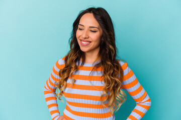 Fototapeta premium Young mexican woman isolated on blue background confident keeping hands on hips.
