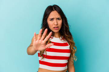 Young mexican woman isolated on blue background rejecting someone showing a gesture of disgust.