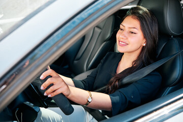 Fototapeta na wymiar young latin woman driving luxury car
