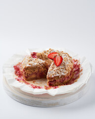 Sweet baked crumble mini cake with strawberry filling on white background, copy space, selective focus.