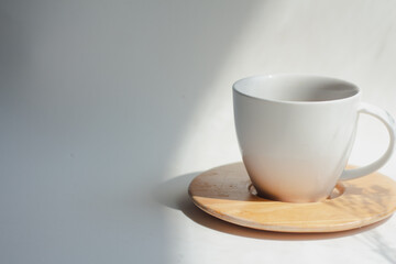 Cup of hot coffee on a white fabric layer with soft light and shadow in the morning, minimal, retro. copy space.