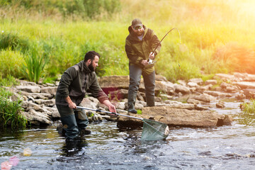 Fototapeta premium young men fishing on a mountain river