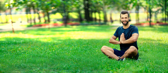 Fototapeta premium Portrait of young brunette bearded man practicing yoga, sitting in half lotus exercise, ardha padmasana pose, working out, meditation session, full length, indoors. Horizontal banner composition.