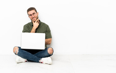 Young man sitting on the floor happy and smiling