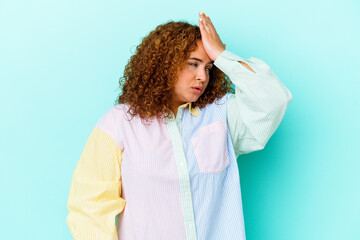 Young latin curvy woman isolated on blue background forgetting something, slapping forehead with...