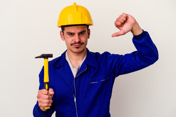 Young caucasian worker man holding a hammer isolated on white background feels proud and self confident, example to follow.