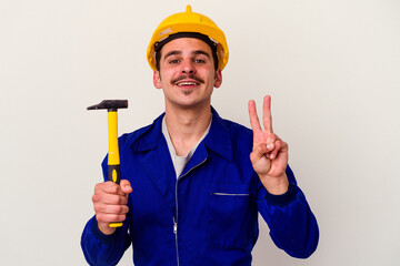 Young caucasian worker man holding a hammer isolated on white background showing number two with fingers.