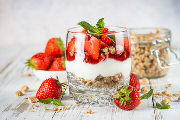 Parfait dessert. Yogurt with fresh strawberry and granola.