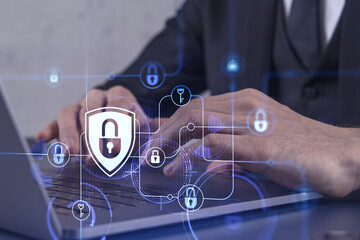 A programmer is typing a code on computer to protect a cyber security from hacker attacks and save clients confidential data. Padlock Hologram icons over the typing hands. Formal wear.