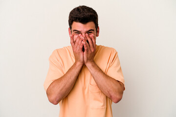 Young caucasian man isolated on white background laughing about something, covering mouth with...