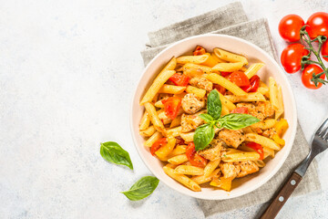 Pasta with chicken and vegetables. Traditional italian food. Top view at white table.
