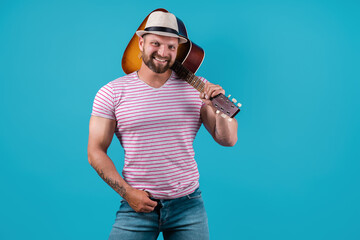 Fototapeta premium Handsome african american retro styled guitarist playing acoustic guitar isolated on blue background