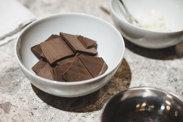 Ingredients for baking homemade sweets: dark chocolate pieces in a bowl.