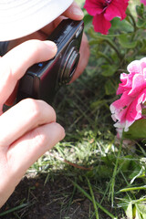 The girl takes pictures of flowers on the camera. St. Veronica's Day Photographer's Day .