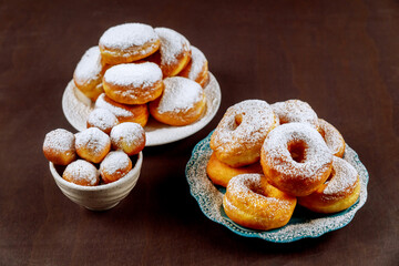 Donuts in white plate powdering with sugar.