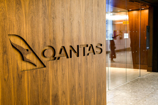 London, England - February 2019:  Qantas sign carved into the wooden panel outside its business lounge in Terminal 3 at London Heathrow Airport