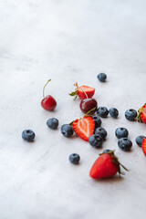 Blueberry, strawberry and cherry on light background