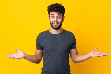 Young Moroccan man isolated on yellow background with shocked facial expression