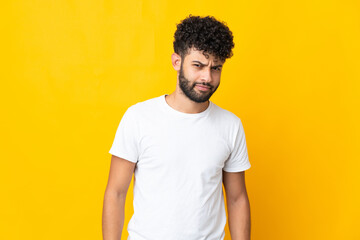 Fototapeta premium Young Moroccan man isolated on yellow background with sad expression