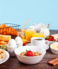 Healthy breakfast. Granola, muesli with fresh berries, cup of coffee, eggs, toasts on the table.