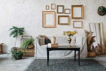 Bohemian room with couch and empty frames above
