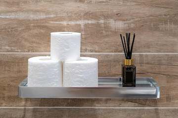 Metal shelf with toilet paper and aroma sticks