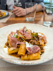 Pasta rigatoni with bolognese sauce, prosciutto and dollops of ricotta cheese