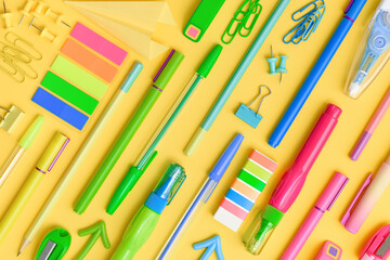 Rainbow lines made with colourful stationery. Office and school multi-colour stationery supply on yellow background as knolling. Flat lay. Back to school or education and creativity pattern. 