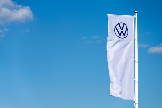 Vilnius, Lithuania - May 16, 2021: The flag of Volkswagen over blue sky. Volkswagen is the biggest German motor vehicle manufacturer